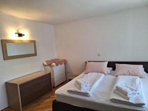 1 dormitorio con 1 cama con 2 toallas en Hotel Dina, en Međugorje