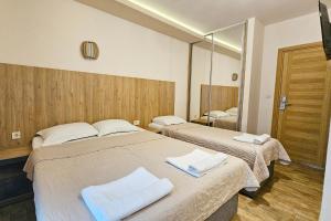 two beds in a hotel room with a mirror at Villa Montemaris Budva in Budva
