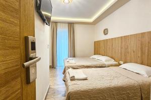 a hotel room with two beds and a flat screen tv at Villa Montemaris Budva in Budva
