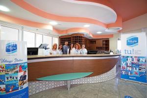 een groep mensen die bij een balie in een tandartspraktijk staan bij Futura Club Itaca Nausicaa in Rossano