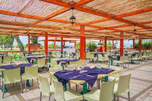 um salão de banquetes com mesas azuis e cadeiras brancas em Futura Club Itaca Nausicaa em Rossano