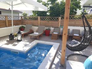 a patio with a hammock and a swimming pool at B&B Buzolic in Hvar