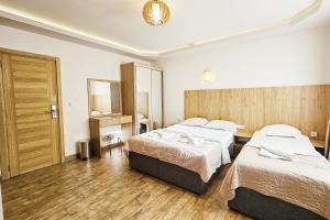 a hotel room with two beds and a mirror at Villa Montemaris Budva in Budva