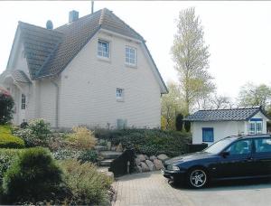 une voiture noire garée devant une maison dans l'établissement Haus-Shanty, à Boren