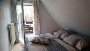 Schlafzimmer mit einem Bett und einer Glasschiebetür in der Unterkunft Haus Shanty in Boren