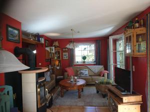 ein Wohnzimmer mit roten Wänden, einem Sofa und einem Tisch in der Unterkunft Haus Shanty in Boren