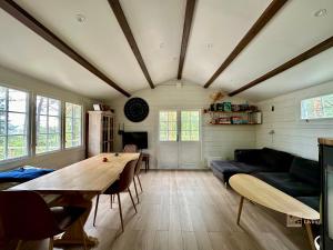 een woonkamer met een tafel en een bank bij Summer cabin in Nesodden open-air bath large terrace in Brevik