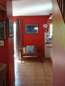 ein Wohnzimmer mit roten Wänden und einer Bank in der Unterkunft Haus Shanty in Boren