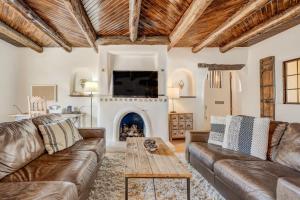 uma sala de estar com sofás de couro e uma lareira em Adobe del Sol - House & Cottage by The Broadmoor em Colorado Springs
