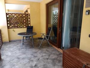 Habitación con mesa, sillas y puerta de cristal. en Sal&Love apt in Porto Antigo, en Santa Maria