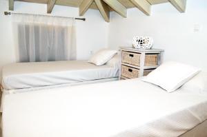 two beds in a room with white walls at Villa Aristoteles in Halki
