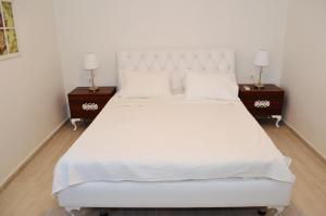 a bedroom with a large white bed with two night stands at Villa Aristoteles in Halki