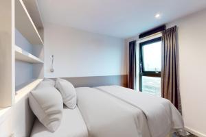 - un lit blanc dans une chambre avec fenêtre dans l'établissement Private Bedrooms with Shared Kitchen, Studios and 2 Bed Apartments at Canvas Manchester, à Manchester