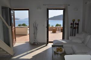 a living room with a white couch and a view of the ocean at Villa Aristoteles in Halki
