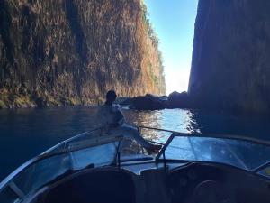 un hombre sentado en el frente de un barco en el agua en Maxola's Dream Orikum, en Orikum