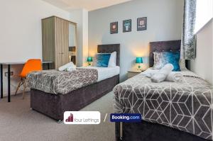 una camera con due letti e una scrivania di 5 Bedroom Contractor House with Free Parking and Free WiFi - Outfield Homes by Your Lettings Peterborough a Peterborough