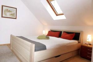 - une chambre avec un grand lit et des oreillers rouges dans l'établissement Wohung mit Balkon und Garten nahe Stadtgrenze, à Glasow