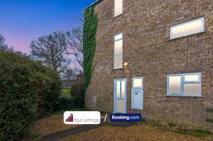una casa in mattoni con una porta blu e un edificio di 5 Bedroom Contractor House with Free Parking and Free WiFi - Outfield Homes by Your Lettings Peterborough a Peterborough
