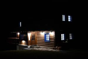 a small wooden house with lights in the dark at Tri borovice in Liptovský Mikuláš