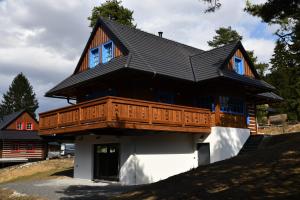 duży drewniany dom z balkonem na górze w obiekcie Tri borovice w Liptowskim Mikulaszu