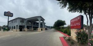 un bâtiment avec un panneau sur le côté d'une rue dans l'établissement Mustang Inn and Suites, à San Antonio