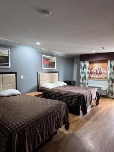 Cette chambre comprend 2 lits et une fenêtre. dans l'établissement Mustang Inn and Suites, à San Antonio
