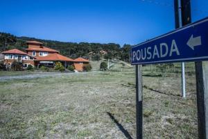 un panneau bleu devant une maison dans l'établissement Pousada Caminhos do Mel - Urubici - SC, à Urubici