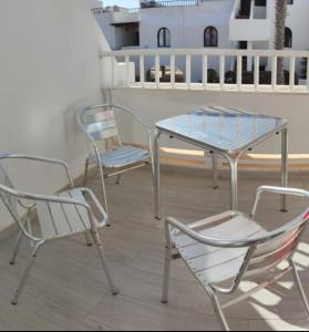 trzy krzesła i stół na balkonie w obiekcie Pistachio 2 w Costa Teguise