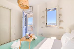 a bedroom with a bed and a table at Paros Sea View Eco - Aetherian Ciel Villas, Niso in Mármara +31 photos