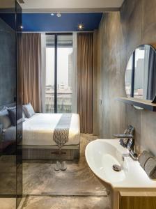 a bedroom with a bed and a sink and a mirror at Hotel Yan in Singapore