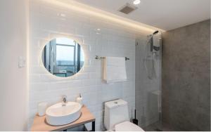 ein Badezimmer mit einem Waschbecken, einem WC und einem Spiegel in der Unterkunft Cove Hillcrest in Buaran