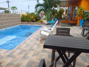 un patio con mesa y sillas junto a una piscina en Posada Ashanty, en Providencia
