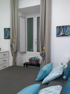 um quarto com uma cama com almofadas azuis em MARGHERITA's Apartment em Salerno