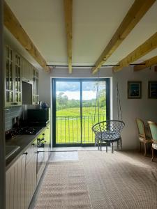 una cucina con una grande porta scorrevole in vetro e un balcone di La Maison de Melman a Quettreville-sur-Sienne