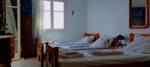 dwa łóżka w pokoju z oknem w obiekcie Καραμπεικο w mieście Piso Livadi