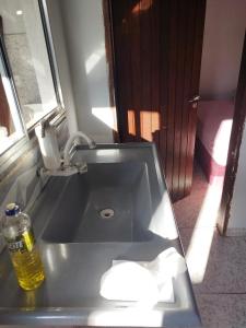 ein Waschbecken mit einer Flasche Wasser darauf in der Unterkunft Casa kitnet Próx da Rodoviária c/ suite e ar condicionado entrada individual . Geladeira e cozinha básica. Garagem pra carro. in Palmas