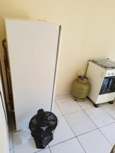 eine Küche mit Kühlschrank und Mülleimer in der Unterkunft Casa kitnet Próx da Rodoviária c/ suite e ar condicionado entrada individual . Geladeira e cozinha básica. Garagem pra carro. in Palmas