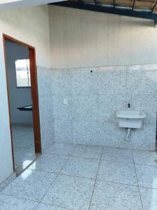 ein Bad mit einem Waschbecken an der Wand in der Unterkunft Casa kitnet Próx da Rodoviária c/ suite e ar condicionado entrada individual . Geladeira e cozinha básica. Garagem pra carro. in Palmas