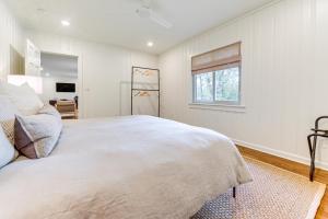 a white bedroom with a large bed and a window at Palmetto Cottage with Fire Pit, Game Table and More! in Fairburn