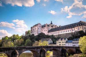 a bridge over a river with a large castle at Ruhige Landhauswohnung in Weilburg in Weilburg