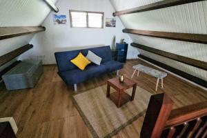 ein Wohnzimmer mit einem blauen Sofa und einem Tisch in der Unterkunft Maison de 3 chambres avec sauna terrasse et wifi a Ducos in Ducos