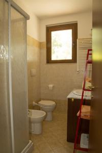 a bathroom with a toilet and a sink and a window at Agriturismo Sant'Orsola in Follonica
