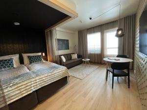um quarto com uma cama grande e uma mesa em Nallikari Holiday Village - Aalto Seaside Apartments em Oulu