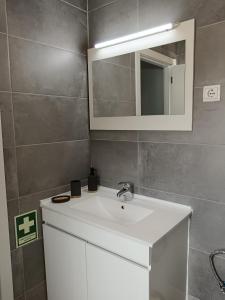 a bathroom with a white sink and a mirror at Casa Fonte do Meio in Folgosa +39 photos