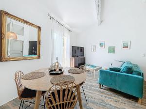 un soggiorno con tavolo e divano blu di Villa "L'émeraude - Maison d'Hôtes - Jardin et parking privés - Valbonne a Valbonne