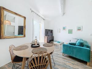 ein Wohnzimmer mit einem Tisch und einem blauen Sofa in der Unterkunft Villa "L'émeraude - Maison d'Hôtes - Jardin et parking privés - Valbonne in Valbonne