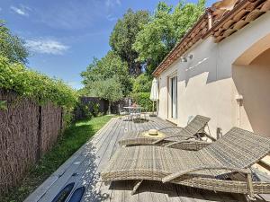 patio con sedie, tavolo e recinzione di Villa "L'émeraude - Maison d'Hôtes - Jardin et parking privés - Valbonne a Valbonne