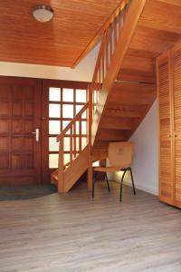 una escalera de madera en una casa con una silla en Ferienhaus für 4 Personen ca 110 qm in Risum-Lindholm, Schleswig-Holstein Kreis Nordfriesland, en Risum-Lindholm