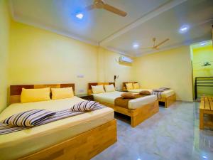 1 dormitorio con 2 camas y 2 mesas en Sparkling Resort Kataragama, en Kataragama