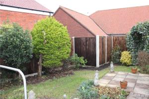 a backyard with a wooden fence and a garden at 3 Harbord road in Cromer +1 photo
